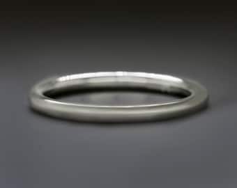 May include: A silver ring with a smooth, rounded design. The ring is made of a shiny, metallic material and has a simple, elegant style. The ring is a classic piece of jewelry.