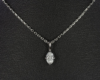 May include: A silver chain necklace with a single oval-shaped diamond pendant.