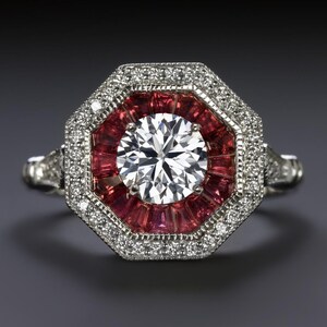 May include: A silver ring with a large, round, clear diamond surrounded by a halo of smaller diamonds and a ring of red rubies.