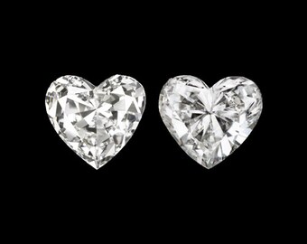 May include: Two heart-shaped diamonds, each with a brilliant cut and facets, set against a black background.