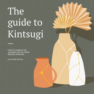 May include: A book cover with the title "The guide to Kintsugi" in white text on a dark green background. The subtitle is "HOW TO HANDLE THE JAPANESE ART OF FIXING BROKEN ARTWORK" in smaller white text. The author's name is "by Camille Perches" in even smaller white text. The cover features three ceramic vases with gold crackle patterns, one orange, one beige, and one white. A dried palm leaf arrangement is in the beige vase.