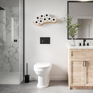 A modern bathroom featuring a wooden wall-mounted toilet paper holder with a wave design, displaying several rolls of toilet paper. The bathroom includes a walk-in shower, a wooden vanity, and a sleek mirror,