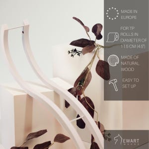 May include: A white curved wooden toilet paper holder with a minimalist design. The text on the image indicates it is made in Europe from natural wood, is easy to set up, and fits toilet paper rolls with a diameter of 11.5 cm or 4.5 inches.