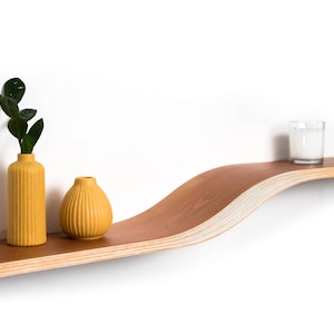 cherry floating wall shelf on white background with yellow vases o top of it