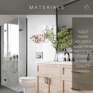 May include: A light-colored wooden toilet paper holder with a hexagonal honeycomb design mounted on a white wall. The text on the image states: MATERIALS. TOILET PAPER HOLDER IS MADE FROM ASH WOOD COVERED WITH HIGH QUALITY VARNISH.