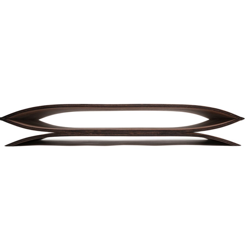 May include: A dark brown, curved wooden object with a smooth, layered finish. The piece features two symmetrical, elongated, and arched horizontal sections that meet at pointed ends, creating a wide, hollow, and oval-shaped opening in the center.