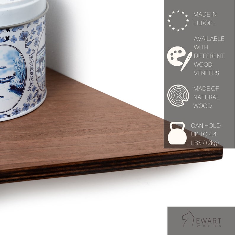 Op de afbeelding: Een driehoekig houten plankje met een donkerbruine afwerking. Het plankje is gemaakt van natuurlijk hout en kan tot 2 kg dragen. Een decoratieve blik met een blauw en wit bloemmotief staat erop. Gemaakt in Europa.