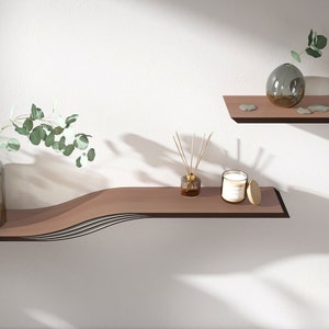 May include: Two wooden shelves, one curved and one straight, with decorative items. The curved shelf has a candle, a diffuser, and a small wooden lid. The straight shelf has a glass vase with a green plant.