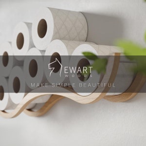 Close-up of a wall-mounted wave design wooden toilet paper holder, displaying several rolls. The EWART WOODS logo and the slogan MAKE SIMPLE BEAUTIFUL are overlaid on the image.