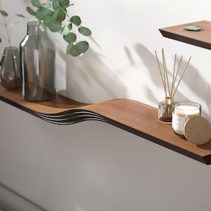 floating wall shelves walnut color attached to a white wall some decors put onto the shelf