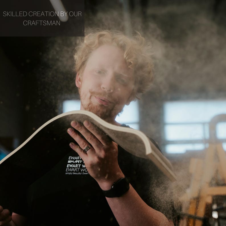 Pu&ograve; includere: Un artigiano lavora il legno, creando un pezzo curvo. L'immagine mostra l'artigiano con un pezzo di legno, con il testo "SKILLED CREATION BY OUR CRAFTSMAN" in alto. L'artigiano indossa una maglietta nera con testo bianco.
