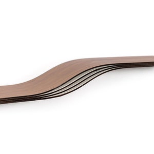 May include: A set of five curved wooden shelves with a dark brown finish. The shelves have a wavy design and are stacked on top of each other, creating a layered effect. The edges of the shelves are visible, showing the different layers of wood.