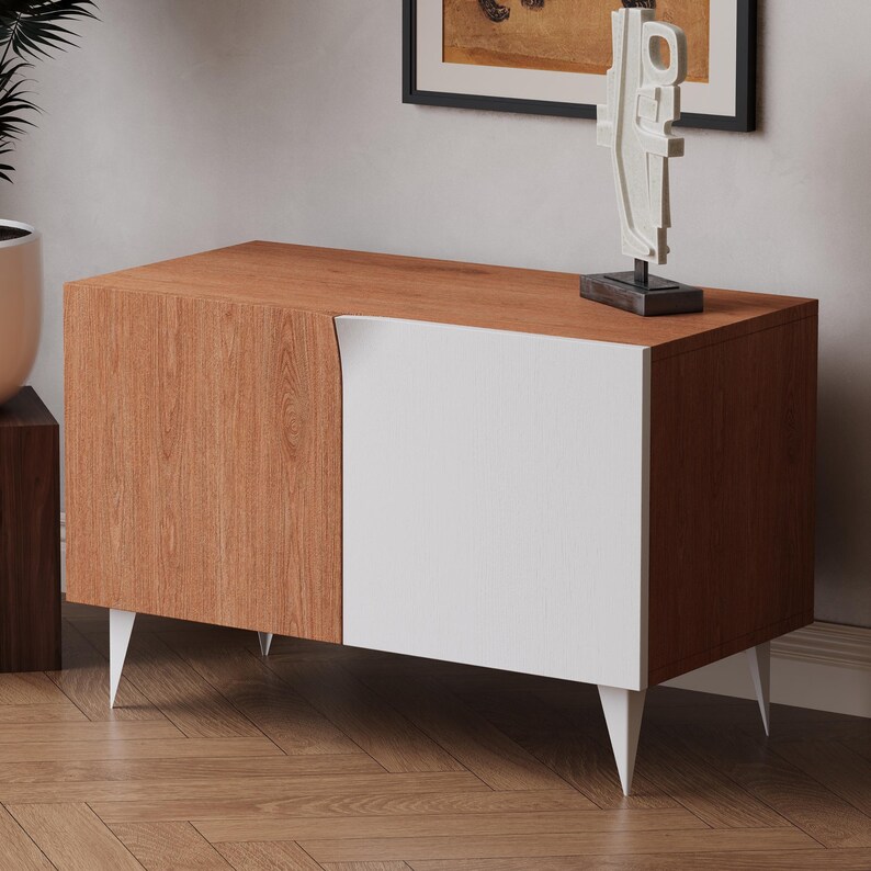 K&ouml;nnte beinhalten: Ein moderner Holzschrank mit einer wei&szlig;en T&uuml;r und einer Holzmaserung. Der Schrank hat vier Beine und steht auf einem Holzboden.