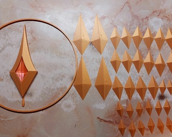 May include: An arrangement of geometric, diamond-shaped objects in varying sizes and a central design within a circle. The objects are a warm, golden color, set against a marbled, beige background. The central design has a red, gem-like center.