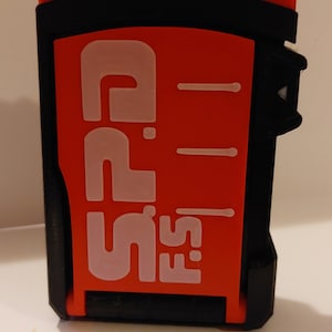 May include: A red and black plastic card with the text "SPD" and "FS" printed in white.
