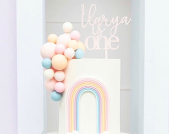 Personalised 1st Birthday cake topper reads: Name is one