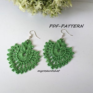 Può includere: Un paio di orecchini all'uncinetto verdi fatti a mano con un design floreale. Gli orecchini presentano un delicato motivo traforato e ganci per le orecchie color argento. Il testo "PDF-PATTERN" è visibile.