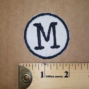 Geborduurde M monogram patch