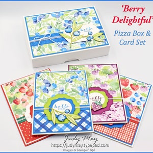 May include: A set of three greeting cards with a blue and white gingham pattern, a red and white gingham pattern, and a purple and white gingham pattern. Each card features a watercolour design of berries and leaves with a "hello there" sentiment. The cards are part of a "Berry Delightful" pizza box and card set.