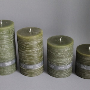 May include: Four green pillar candles with a textured finish and a gray label that reads "Lemon Grass".