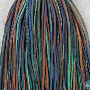 May include: A set of blue, green, brown, and orange wool dreadlocks. The dreadlocks are made of wool yarn and are approximately 24 inches long.