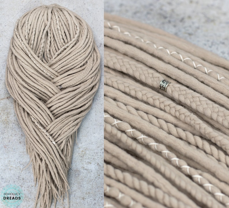 Pu&ograve; includere: Un set di dreadlock sintetici color beige con un mix di ciocche lisce, intrecciate e cucite con filo bianco. La collezione include una perlina in metallo argentato con incisioni complesse. Il testo BOHOLUCY DREADS &egrave; visibile in basso.