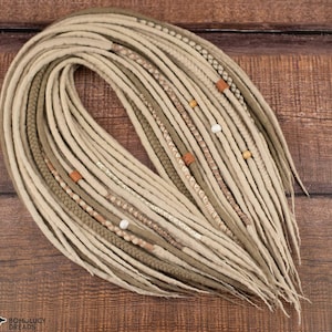 May include: A set of beige and brown synthetic dreadlocks with beads and leather accents.