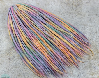 May include: A set of colorful wool dreadlocks in shades of pink, purple, yellow, and green. The dreadlocks are tied together at the top and have a braided design.
