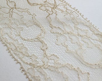 May include: Beige lace trim with a delicate floral pattern. The lace is soft and sheer, with a slightly textured finish.