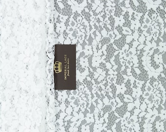 May include: White lace fabric with a delicate floral pattern. The fabric is soft and sheer, and it has a subtle sheen. The fabric is perfect for a variety of projects, including clothing, home decor, and crafts.
