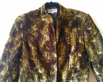 May include: A brown and green patterned blazer with a mandarin collar and a button closure. The label reads "Giorgio Armani" and "Made in Italy".