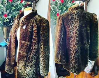 May include: A brown and black leopard print faux fur jacket with a collar and long sleeves.