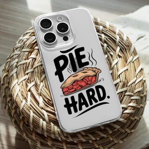 Könnte beinhalten: Eine transparente Handyhülle mit weißem Hintergrund und einer Illustration einer roten und braunen Torte. Der Text "Pie Hard" ist in schwarzen Buchstaben geschrieben.