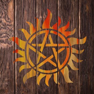 K&ouml;nnte beinhalten: Eine stilisierte Sonne mit einem Pentagramm im Inneren, in Orange- und Gelbt&ouml;nen auf einem dunkelbraunen Holzgrund gemalt.