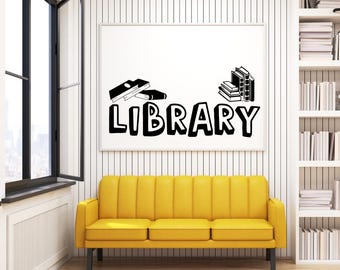 May include: A white wall with a black and white graphic of books and the word "LIBRARY" on a white frame. A yellow couch is in front of the wall. A bookshelf with books is on the right side of the image.