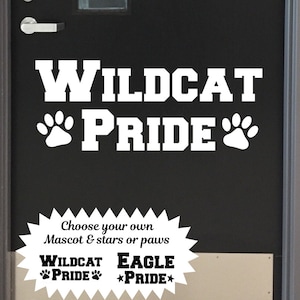 Puede incluir: Calcoman&iacute;a de vinilo blanco con las palabras "WILDCAT PRIDE" en una fuente en negrita. Dos huellas de patas est&aacute;n a cada lado de la palabra "PRIDE". Debajo de la calcoman&iacute;a hay una estrella blanca con el texto "Choose your own Mascot & stars or paws WILDCAT PRIDE EAGLE PRIDE".