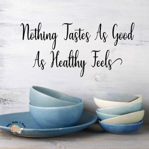 May include: A stack of blue and white ceramic bowls on a wooden surface with the text "Nothing Tastes As Good As Healthy Feels" written on a white wall behind the bowls.