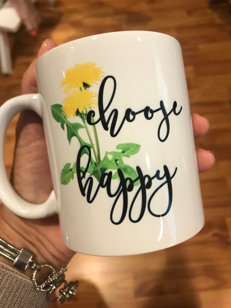 May include: White ceramic mug with a dandelion design and the text "choose happy" in black script.