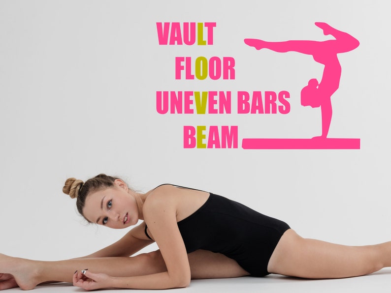 May include: A young woman in a black leotard is stretching on a white background. The words "VAULT", "FLOOR", "UNEVEN BARS", and "BEAM" are written in yellow on the wall. A pink silhouette of a gymnast performing on a balance beam is also on the wall.