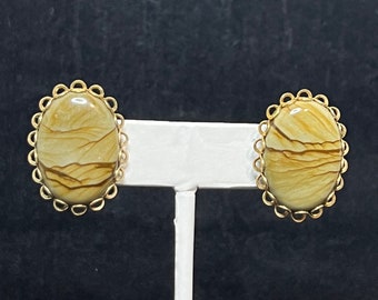May include: A pair of gold tone earrings with oval shaped brown and white agate stones set in a decorative gold tone frame.