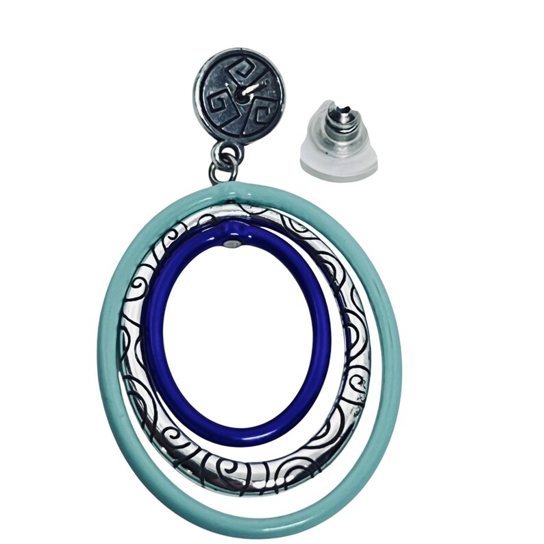 Puede incluir: Un pendiente plateado con un dise&ntilde;o circular. El pendiente presenta tres aros conc&eacute;ntricos: un aro exterior azul claro, un aro central de filigrana plateada y un aro interior azul oscuro. El poste del pendiente tiene una parte superior plateada decorativa.