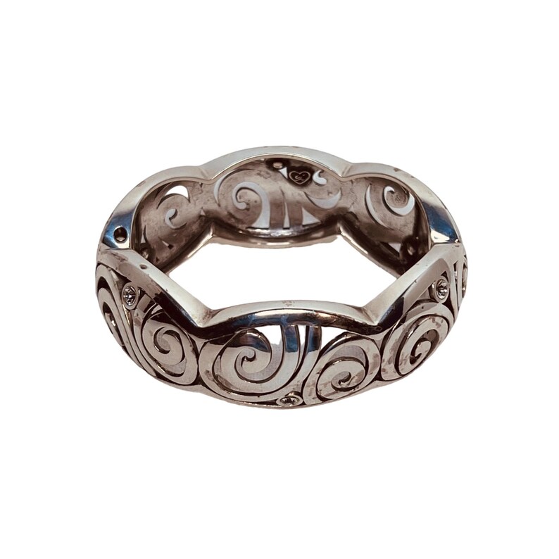 以下が含まれることがあります： 渦巻き模様と小さな透明な石が付いた銀のリング。リングは開いており、内側にハートのチャームが付いています。