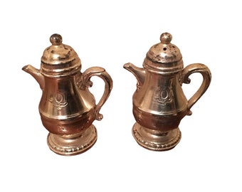 May include: A set of two silver-tone metal salt and pepper shakers shaped like coffee pots.