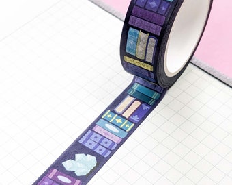 May include: A roll of washi tape with a black background and a pattern of colorful books. The tape is unrolled on a white gridded notebook.