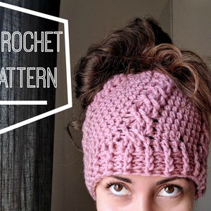 May include: A pink crocheted headband with a textured pattern. The headband is worn by a person with brown hair.