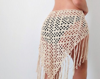 May include: A white crochet skirt with fringe detailing. The skirt is made of a lightweight, airy fabric and has a loose, flowing fit.