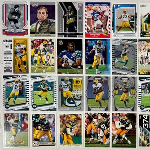 May include: A collection of Green Bay Packers football trading cards. The cards feature players in their uniforms, action shots, and team logos. Some cards have the text "SEASON" and "FLIGHT TO 480".