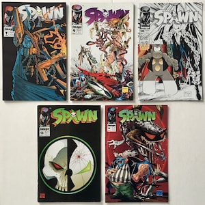 May include: A collection of five Spawn comic books, featuring the character Spawn on the covers. The covers are in various colors, including red, black, white, and blue. The comic books are numbered 7, 9, 10, 12, and 14.