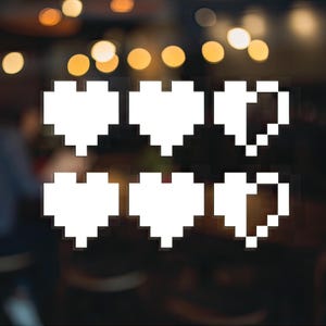 May include: Six white pixelated hearts arranged in two rows of three. The hearts are on a blurred background of lights.