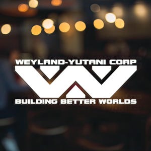 以下が含まれることがあります： 「Weyland-Yutani Corp. Building Better Worlds」というテキストと、スタイリッシュな「W」ロゴが書かれた白いステッカーです。